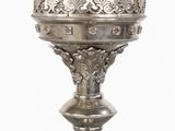 a silver vase with a crown on top of it