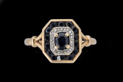 un gros plan d'une bague en or sertie d'un diamant noir et blanc