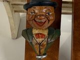 a wooden sculpture of a man with a top hat and a bottle opener