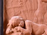carvings of a woman and a child on a wall in front of a building
