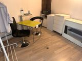 a yellow table and black chair in a small room
