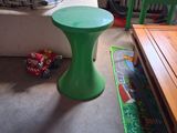 une petite table verte dans un coin du salon