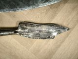 a knife that is laying on a table next to a knife