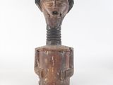 une vieille sculpture en bois représentant un homme coiffé d'un chapeau
