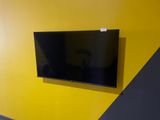a flat screen tv mounted on a yellow wall in a room