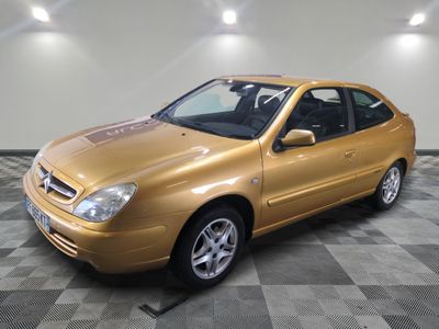 une photo d'une voiture de couleur dorée dans un garage