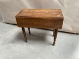 une vieille table en bois surmontée d'un petit tiroir