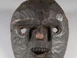 une image représentant un masque en bois dont le visage est sculpté dans le bois