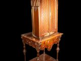 an old wooden table with a carved top on a black background