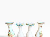 three white vases with floral designs are lined up against a white background