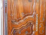 a wooden armoire with carvings on the doors
