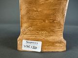 a brown vase that has a tag on it