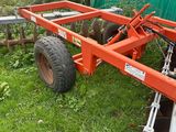 a tractor with a trailer attached to it in the grass