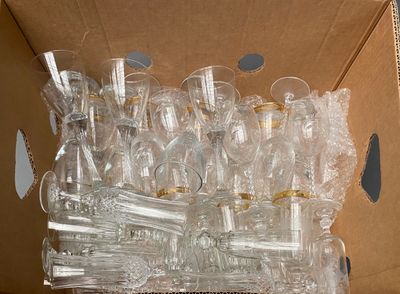 a lot of empty wine glasses in a cardboard box