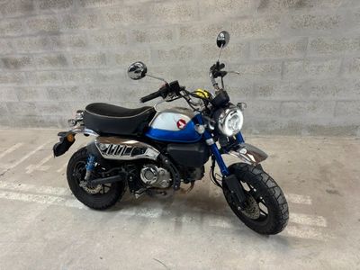 a blue and white motorcycle parked in a parking lot