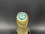 a close up of a beer bottle on a metal surface