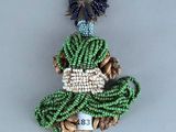 broche en perles représentant une femme en robe verte