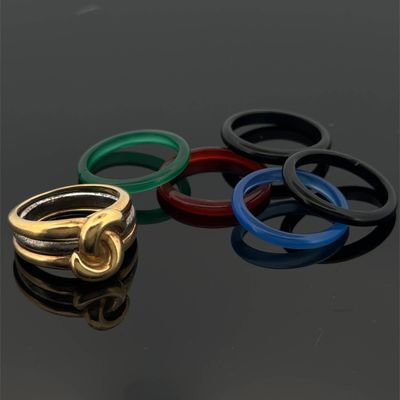 four different colored rings sitting on top of a black surface