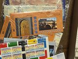 a pile of postcards on a table next to a picture frame