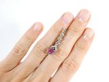 an image of a woman ' s hand with a diamond and ruby ring