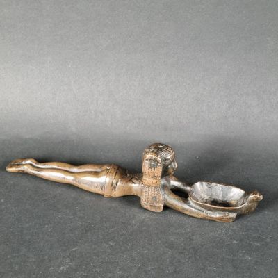 une figurine antique en bronze représentant une femme allongée sur le ventre
