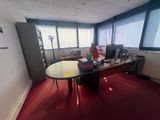 une image représentant un bureau avec une table et des chaises