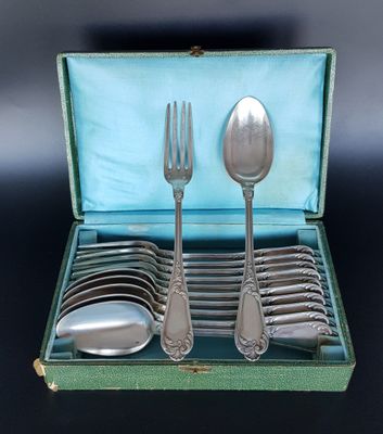 a green case with silverware in it on a black surface