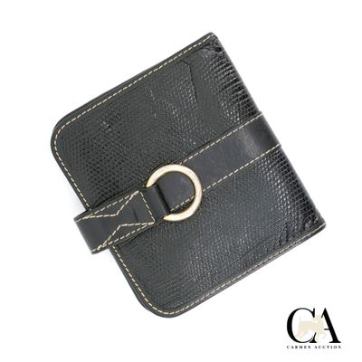 Le portefeuille en cuir noir est orné d'une boucle dorée sur le devant.