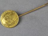 a close up of a gold coin on a stick on a table