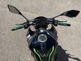 a black and green motorcycle parked in a parking lot
