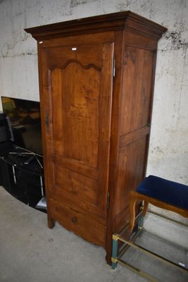 a wooden cabinet and a chair in the corner of a room