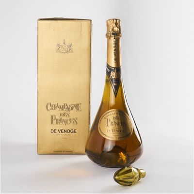 une image représentant une bouteille de champagne à côté d'un coffret doré