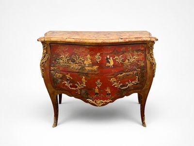 une vieille commode ornée d'un motif rouge et or