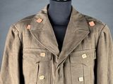 a brown jacket on a mannequin stand with a gray background