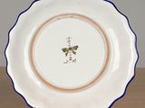 a white plate with a blue border and a butterfly on it