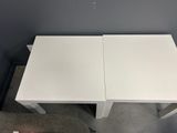 a white table with two chairs on top of it in a room