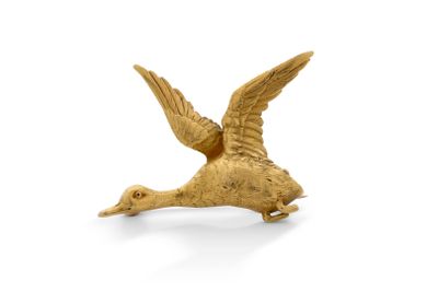 une statue dorée représentant un oiseau sur fond blanc