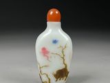 a small glass bottle with a painting on it