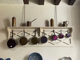 une photo d'une cuisine où des casseroles et des poêles sont suspendues au plafond