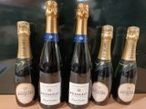 cinq bouteilles de champagne sont alignées sur une table