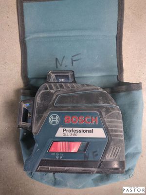 Le niveau laser Bosch Professional est posé par terre à côté du sac à outils.