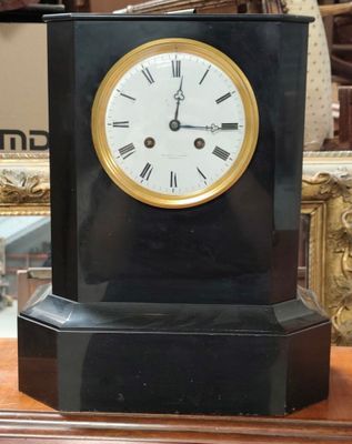 a clock that is sitting on a table in front of a mirror