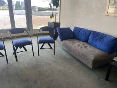 un salon avec un canapé, des chaises et une table basse