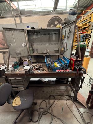 une photo d'un établi dans un atelier, avec des outils
