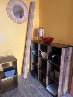 une étagère en bois sur laquelle est posé un bol, dans un coin de la pièce