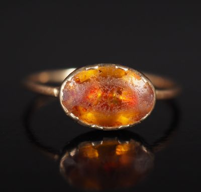 une bague en or avec une pierre orange au centre