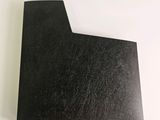 a close up of a piece of black paper on a white surface