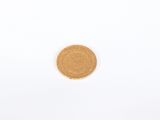 a close up of a gold coin on a white surface