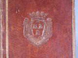 a brown leather book with a crest on it