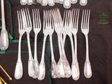 a lot of silver forks and spoons on a table